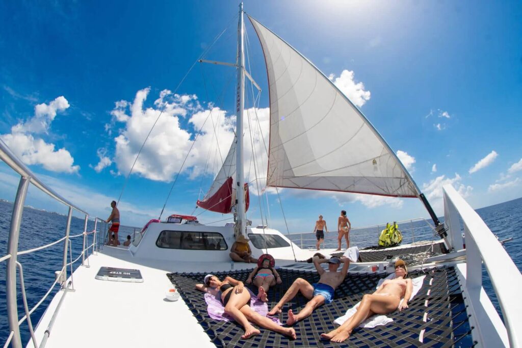 A group of people enjoying a Sandbar Sail on the deck of a catamaran.