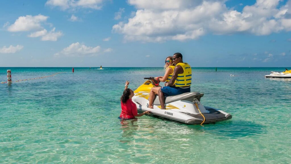 Two people on jet skis enjoying the crystal-clear blue water.