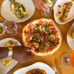 A group of people sitting around a table with plates of food.
