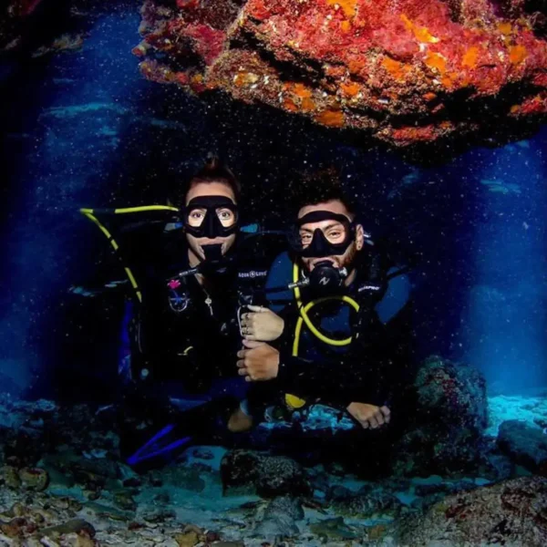 Two scuba divers posing in a cave.
