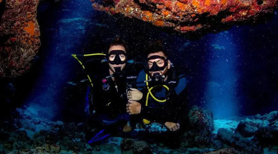 Two scuba divers posing in a cave.