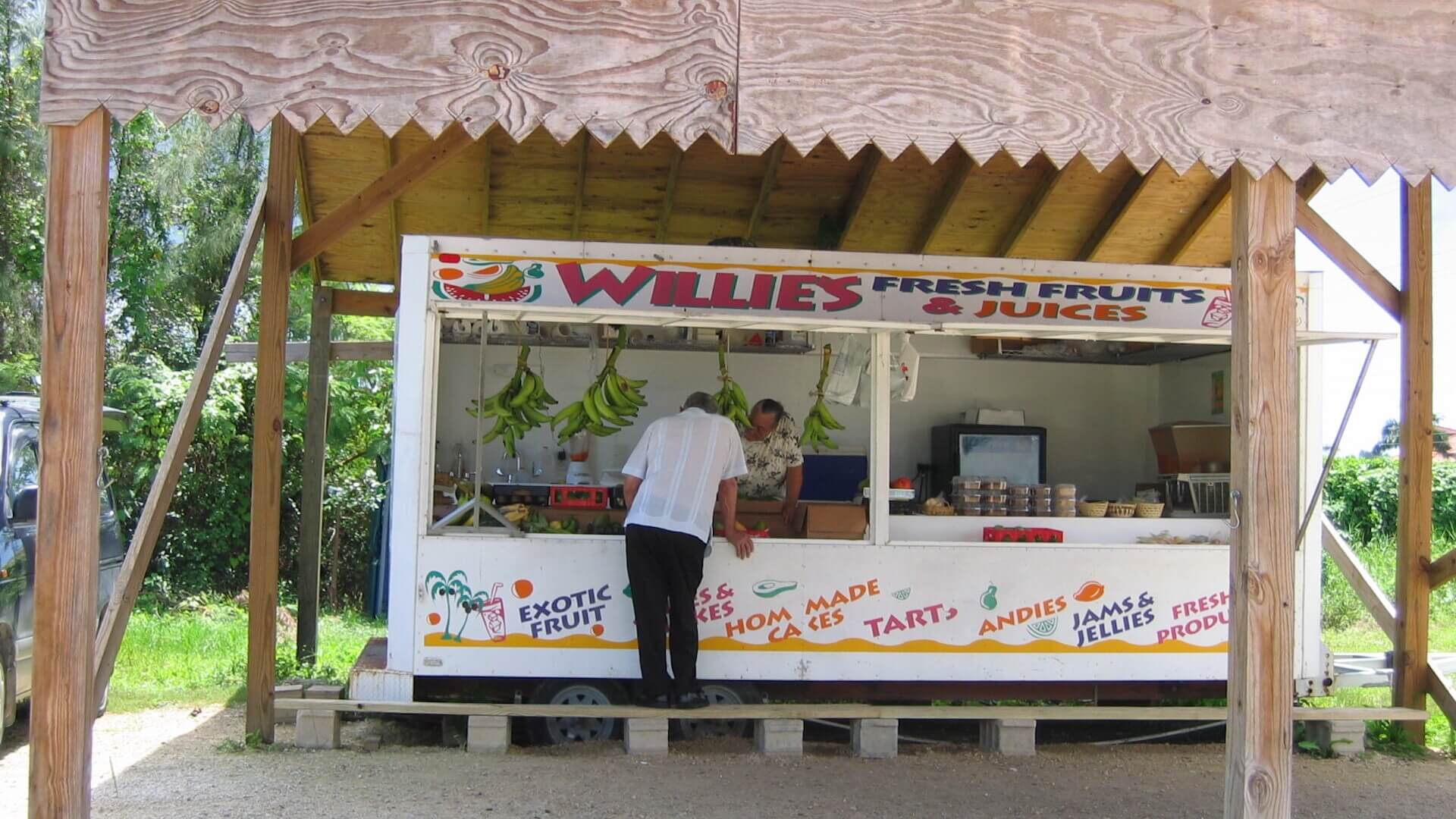 A food stand with a man standing in front of it.
