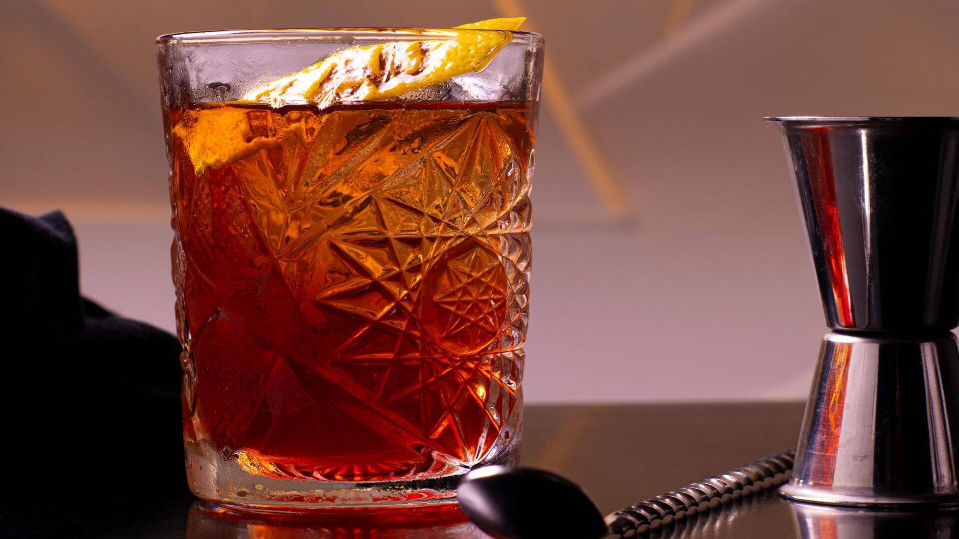 An old fashion glass with rum and a slice of lemon.